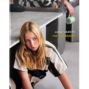 Young girl with blonde hair wearing a black and white prison jumper. Text overlay Adad Hannah The Diversions