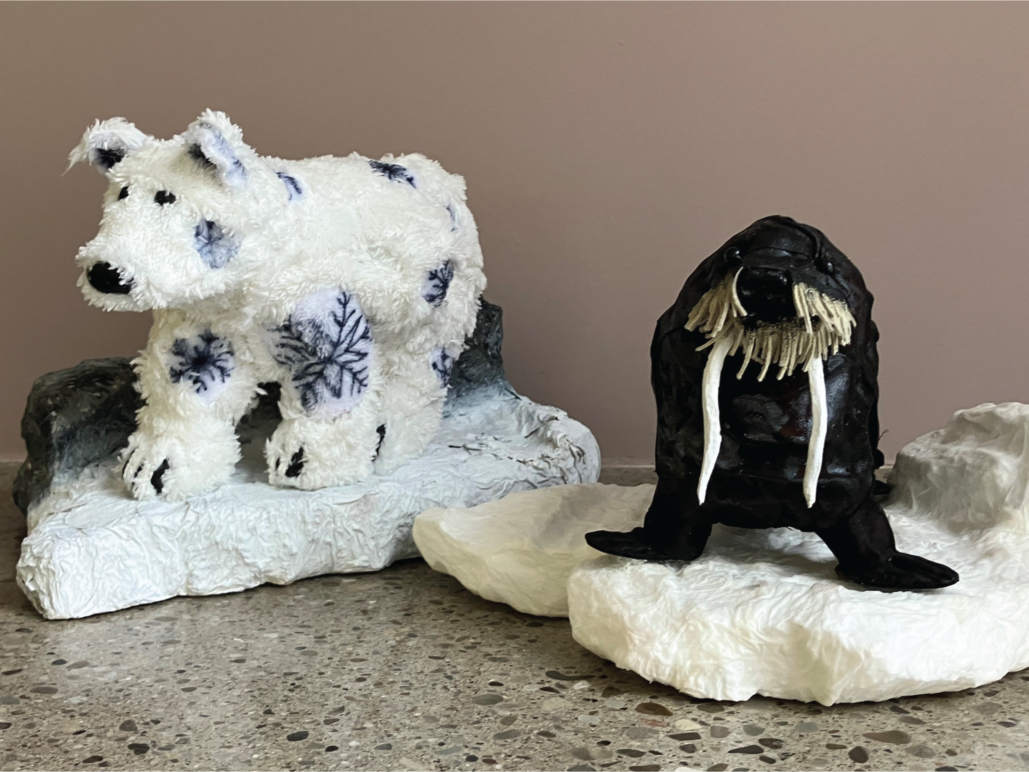 Painted clay sculptures of a walrus and polar bear, mounted to a painted clay iceburg.