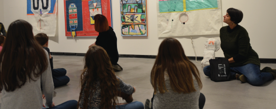 Kids sitting on the floor, admiring art.